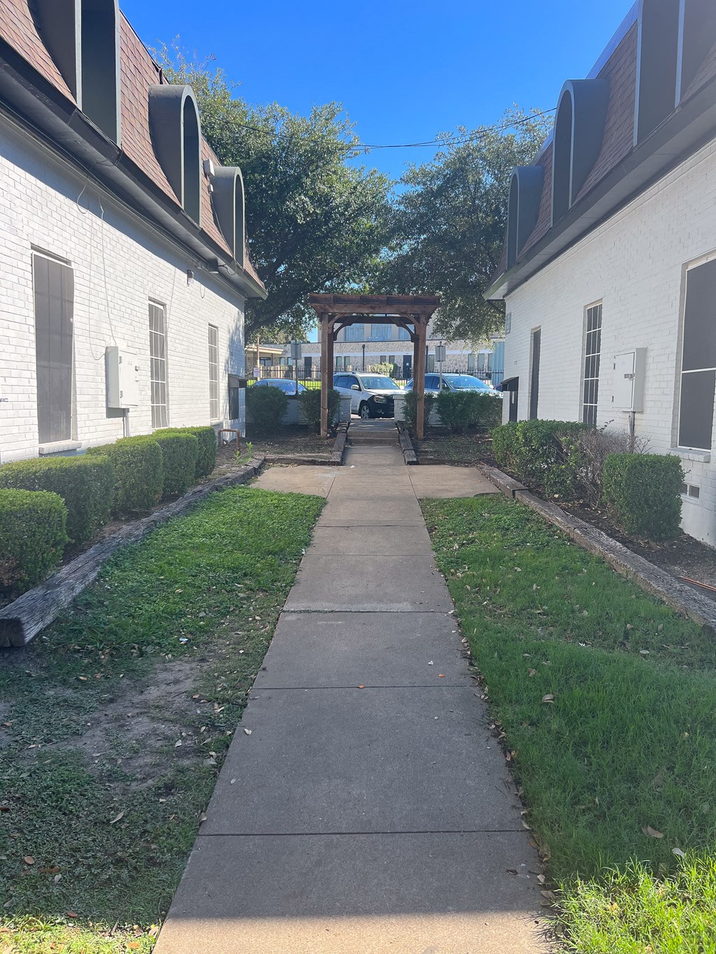 a walkway between two buildings with a wooden structure in the middle