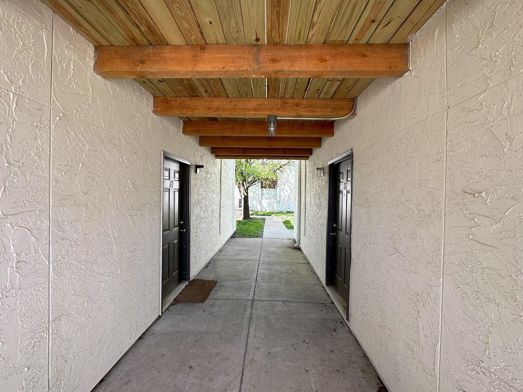 a hallway with doors and a wooden ceiling