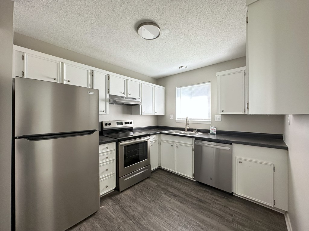 a kitchen with white cabinets and stainless steel appliances