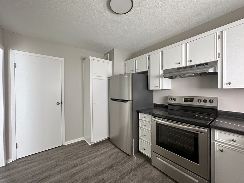 a kitchen with white cabinets and stainless steel appliances