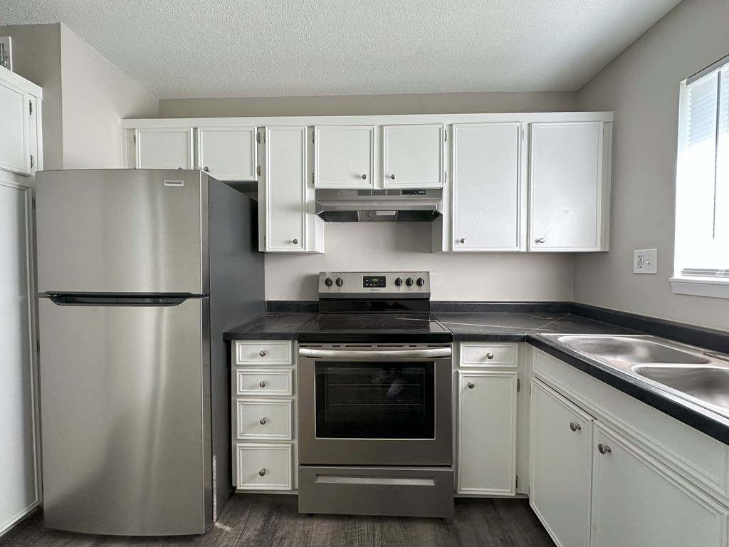 a kitchen with white cabinets and stainless steel appliances
