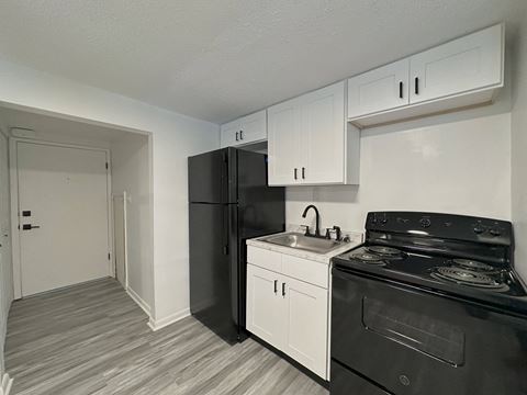 a kitchen with white cabinetry and black appliances