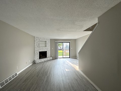 an empty living room with a fireplace