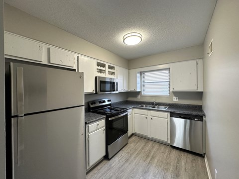 a kitchen with white cabinets and stainless steel appliances