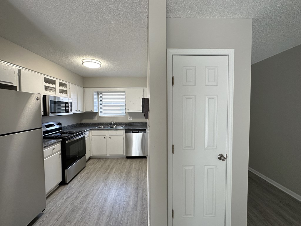 a kitchen with white cabinets and stainless steel appliances
