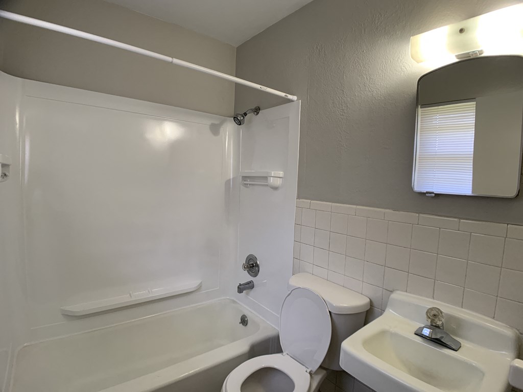 Full bathroom with tub, toilet and vanity