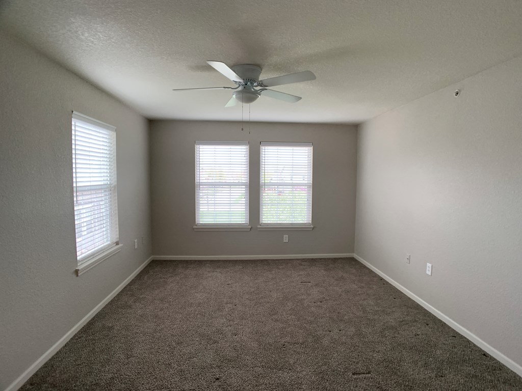 Bedroom with large windows and ceiling fan at Saddlewood in Olathe, KS