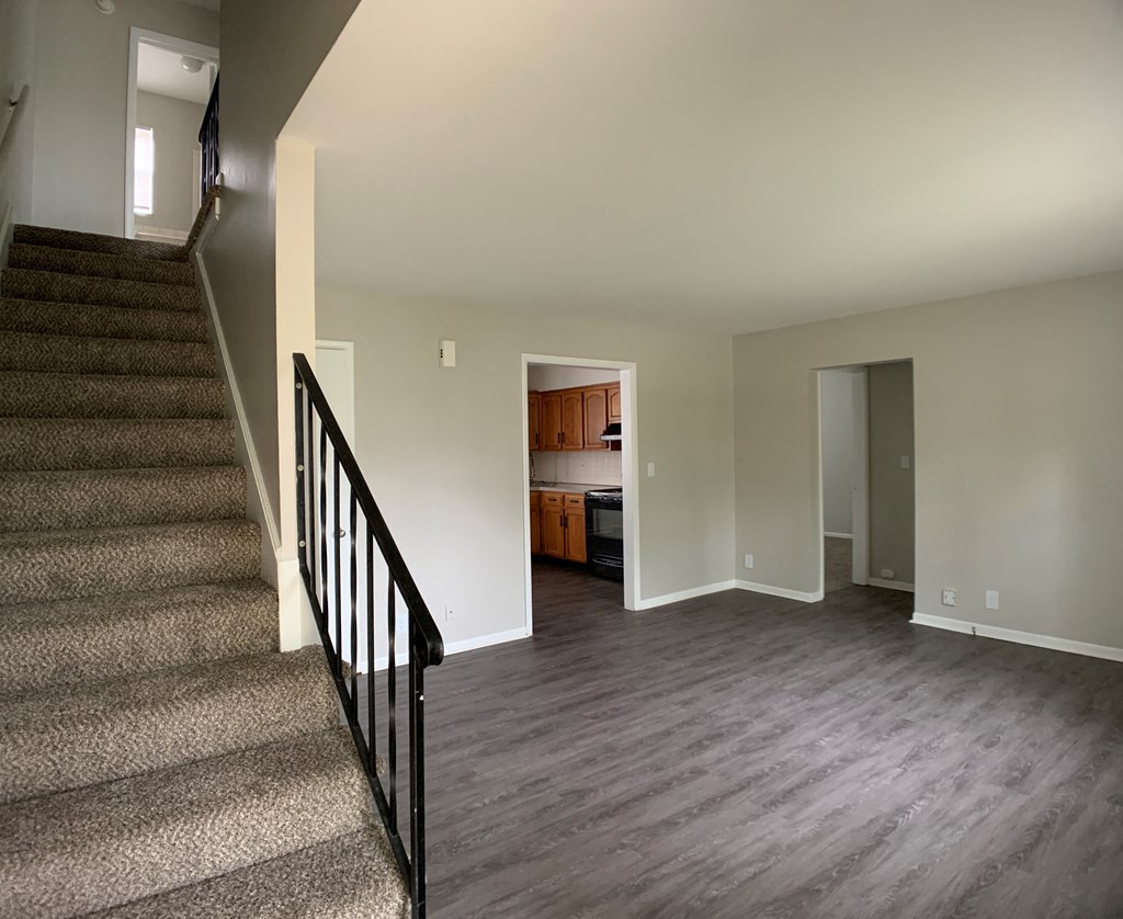 Spacious living room with open concept to kitchen and stairs