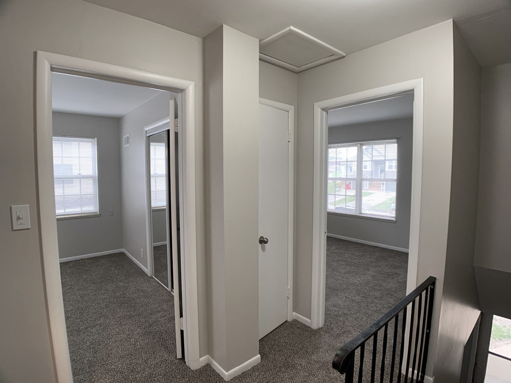 View of 2 bedrooms from top of stairs