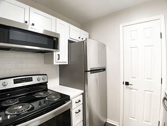 Photo of kitchen with white cabinetry and stainless steel appliances in Kansas City.