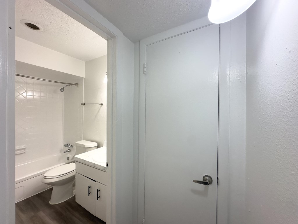 A white bathroom with a toilet, sink, and shower.