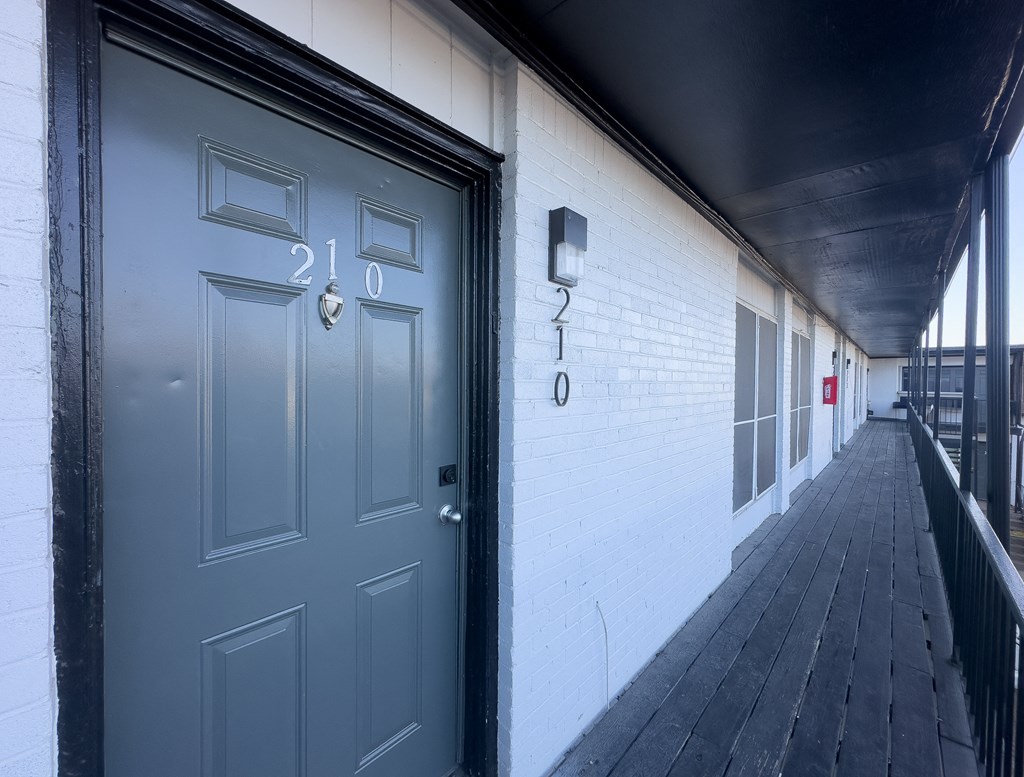 A black door with the number 210 on it.