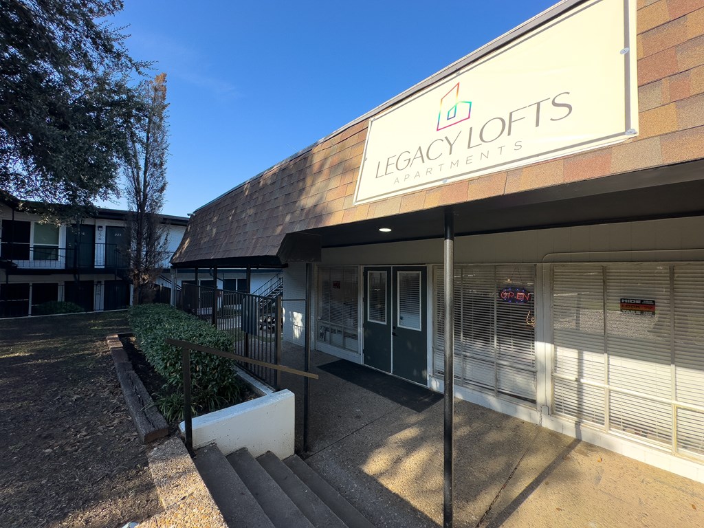 The front of a building with the sign "Legacy Lofts Apartments" on it.