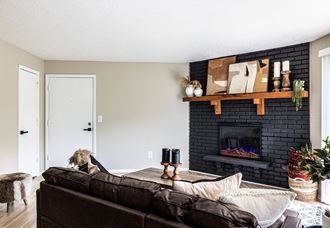 a living room with a black fireplace and a brown couch
