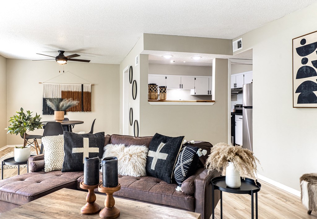 a living room with a brown couch and black and white pillows