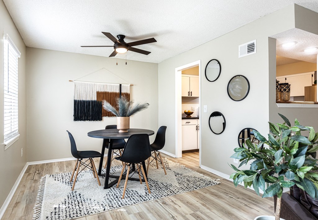 a dining room with a table and chairs and a ceiling fan
