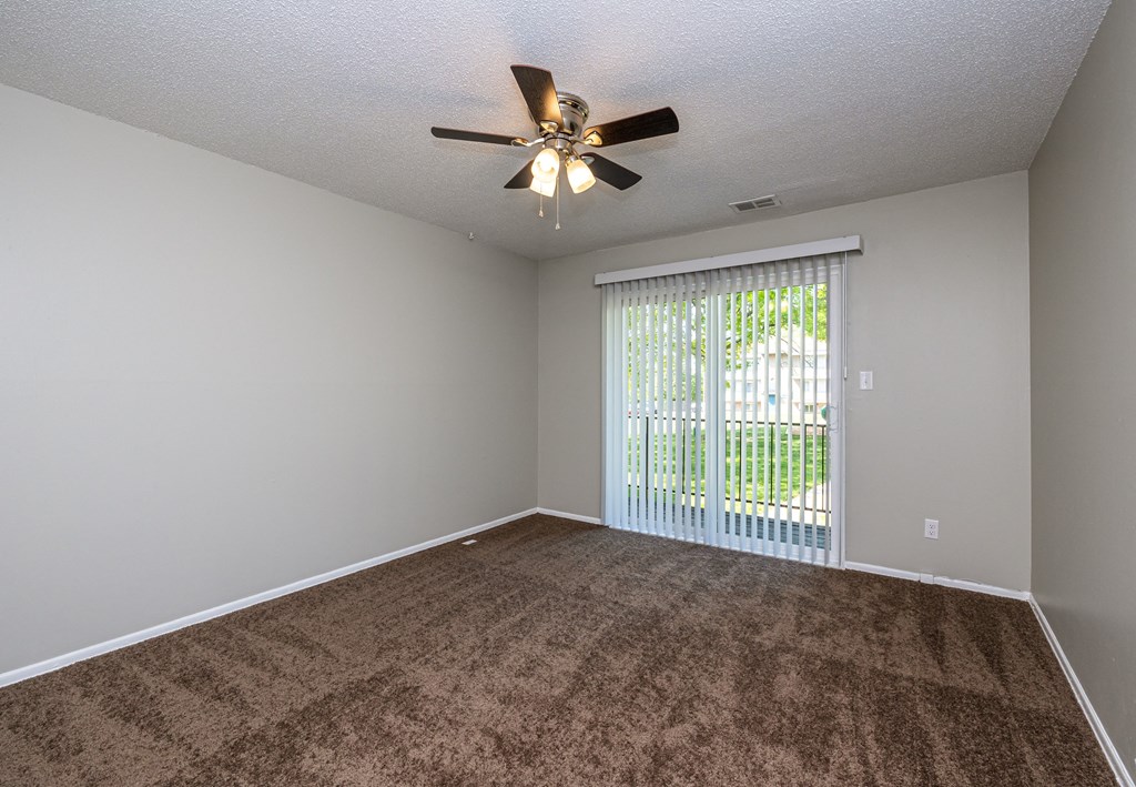 a bedroom with a ceiling fan and a window
