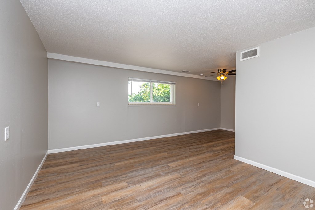 a bedroom with hardwood floors and grey walls