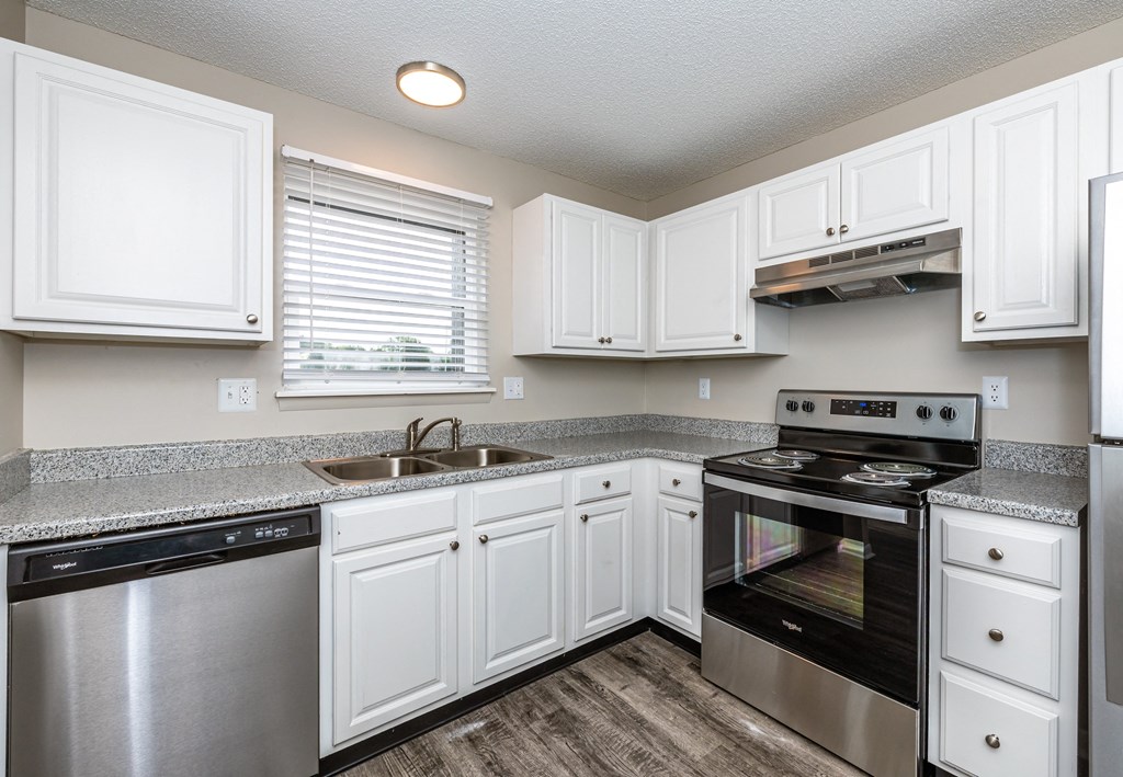 a kitchen with white cabinets and black appliances