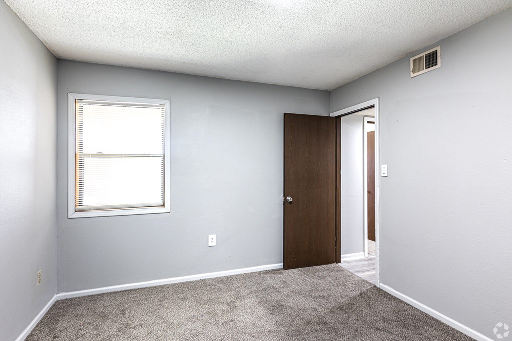 an empty room with a window and a door