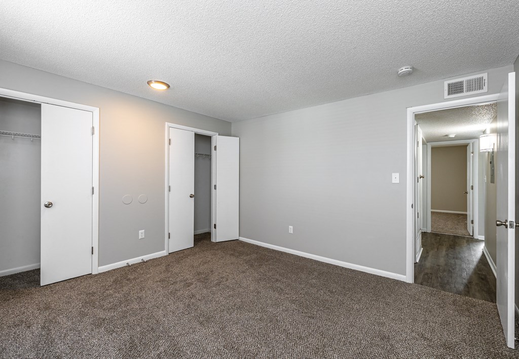 a bedroom with a carpeted floor and two doors