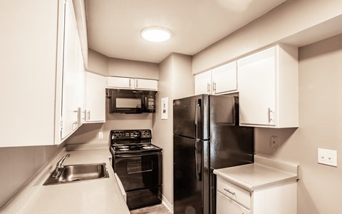a kitchen with black appliances and white cabinets