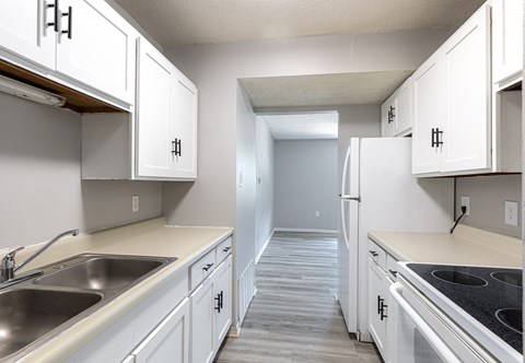 A kitchen with white cabinets and a stainless steel sink.
