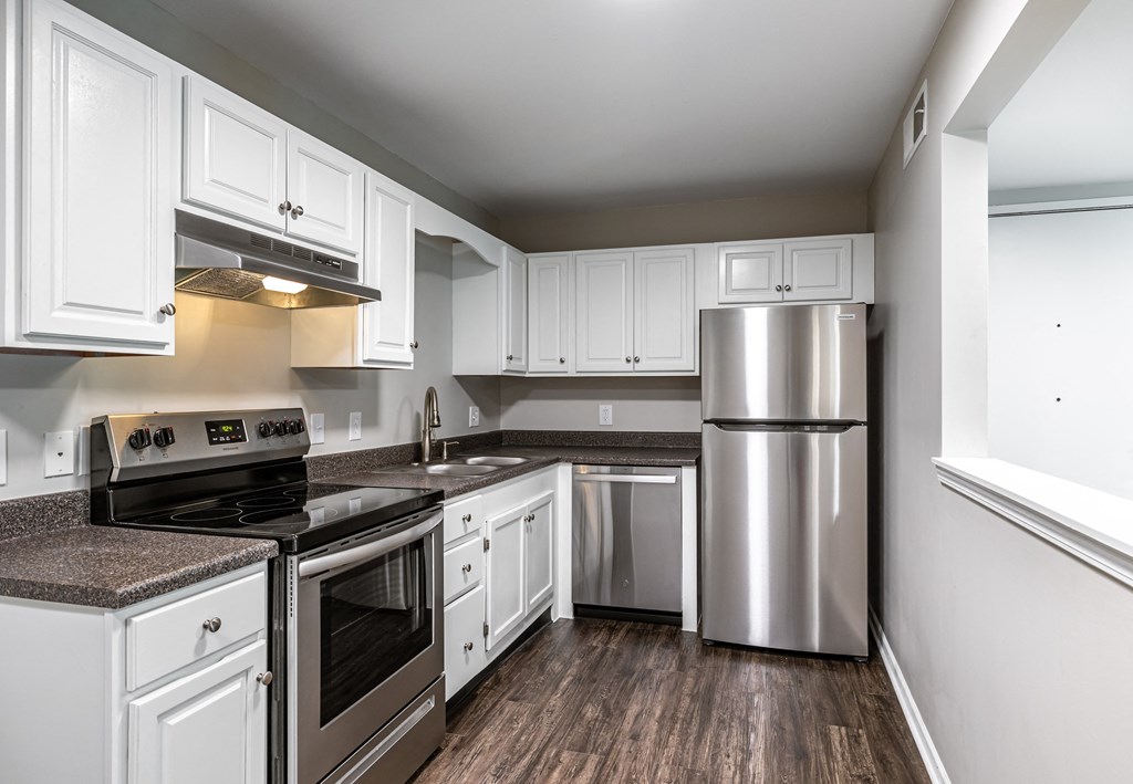 a kitchen with white cabinets and stainless steel appliances
