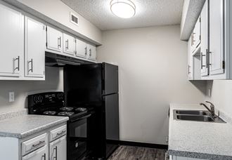 a kitchen with white cabinets and black appliances