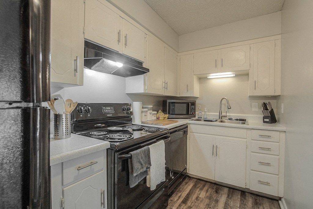Photo of kitchen with white cabinetry and stainless steel appliances.
