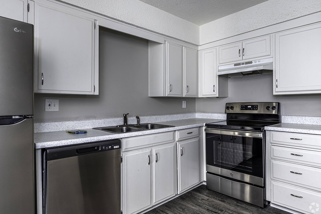 Photo of kitchen with white cabinetry and stainless steel appliances.