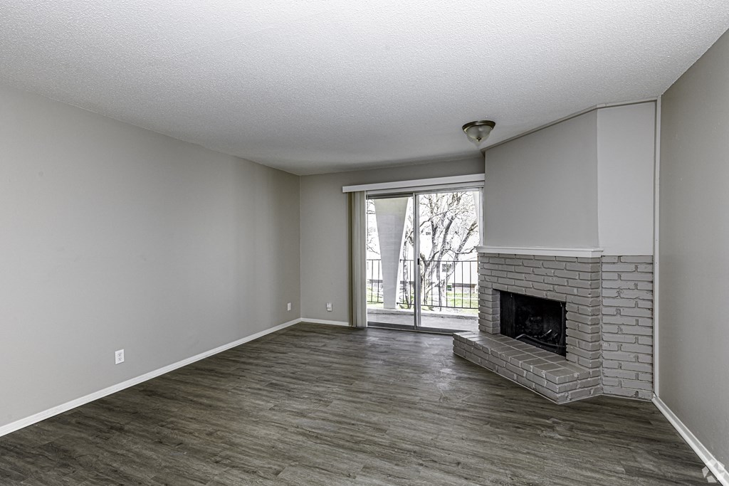 Photo of fireplace and living area, vinyl flooring throughout and stone wall for the fireplace.