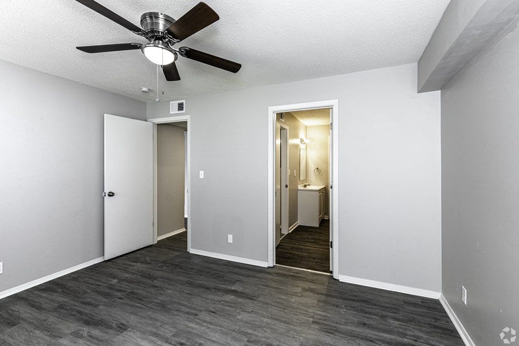 Photo of bedroom with vinyl flooring and ceiling fan.