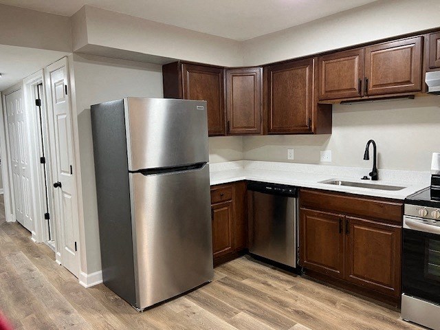 a kitchen with a stainless steel refrigerator and wooden cabinets