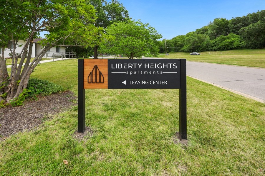a sign for liberty heights park in front of a road