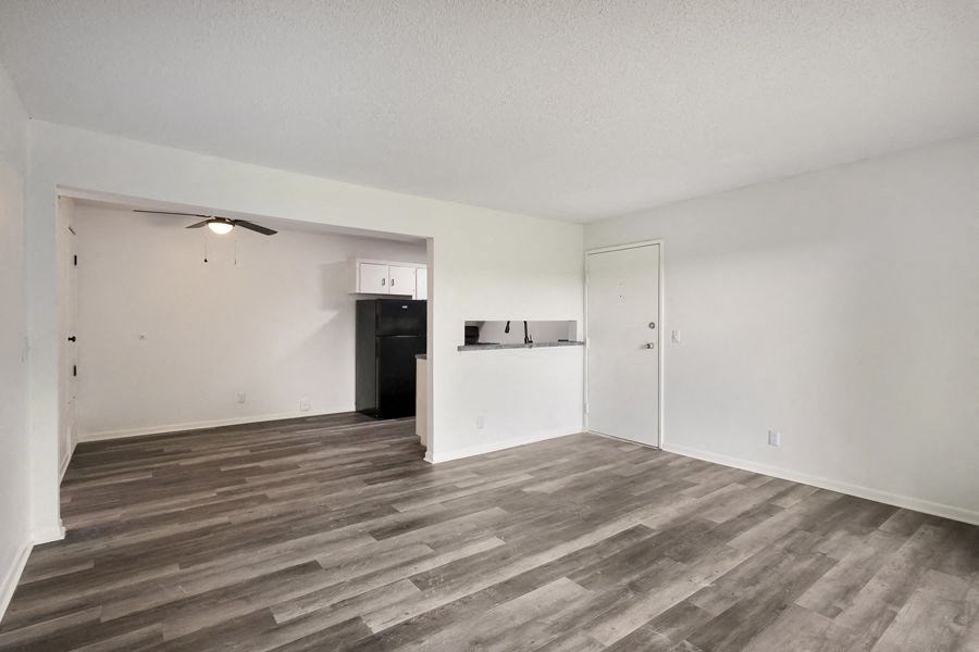 an empty living room with white walls and wood floors