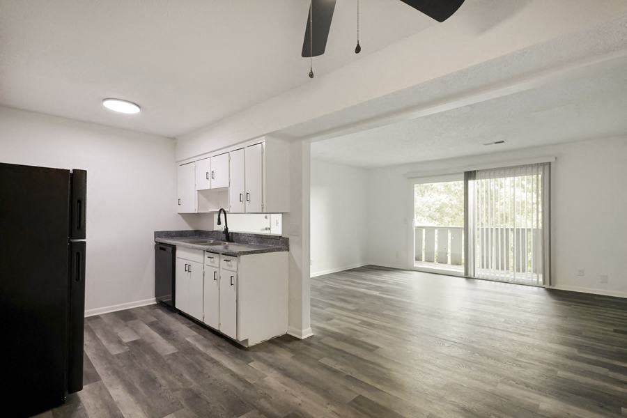 an empty kitchen and living room with a sliding glass door