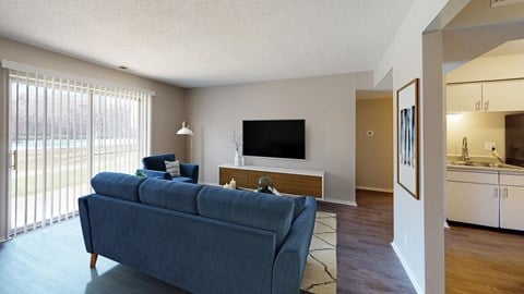 the living room of a apartment with a blue couch and a tv