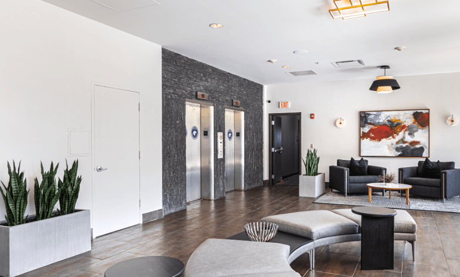a living room with couches and chairs and a lobby with elevators