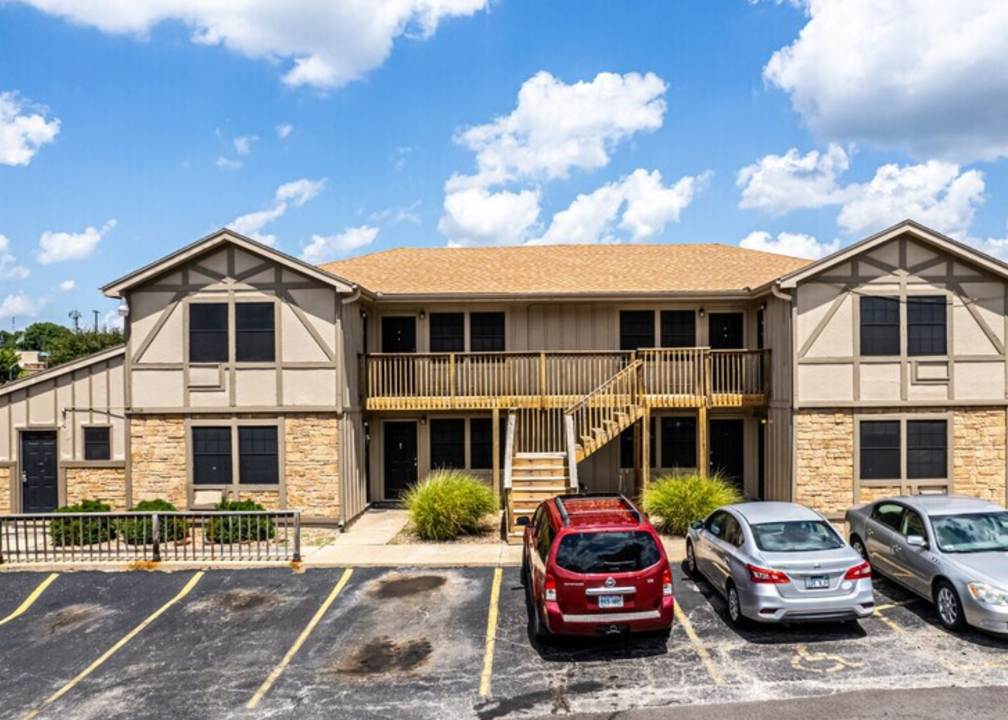 an apartment building with cars parked in front of it