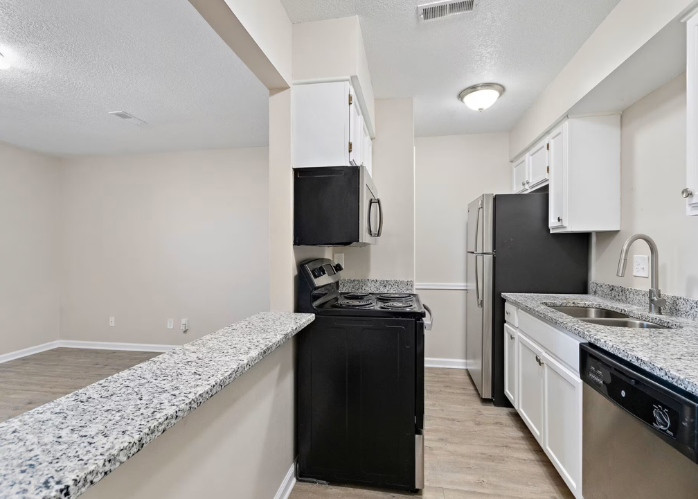 a kitchen with white cabinets and black appliances