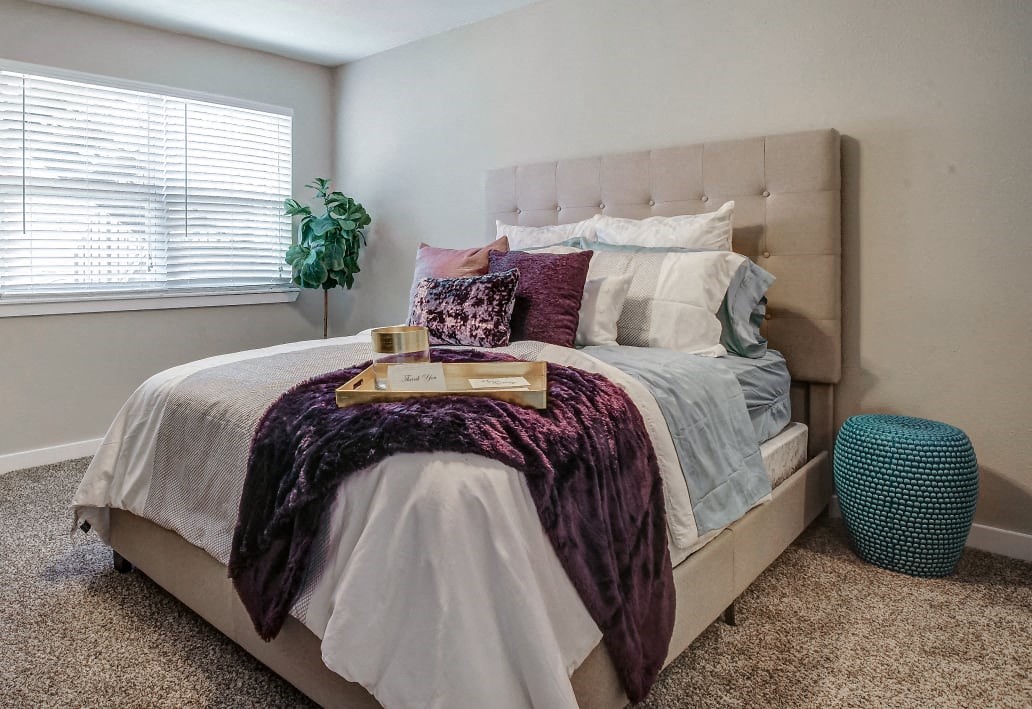 Image of master bedroom with plush carpet and large bed.