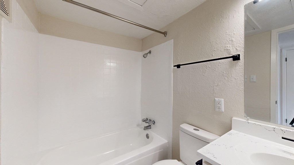 a bathroom with a white toilet and a tub and a sink