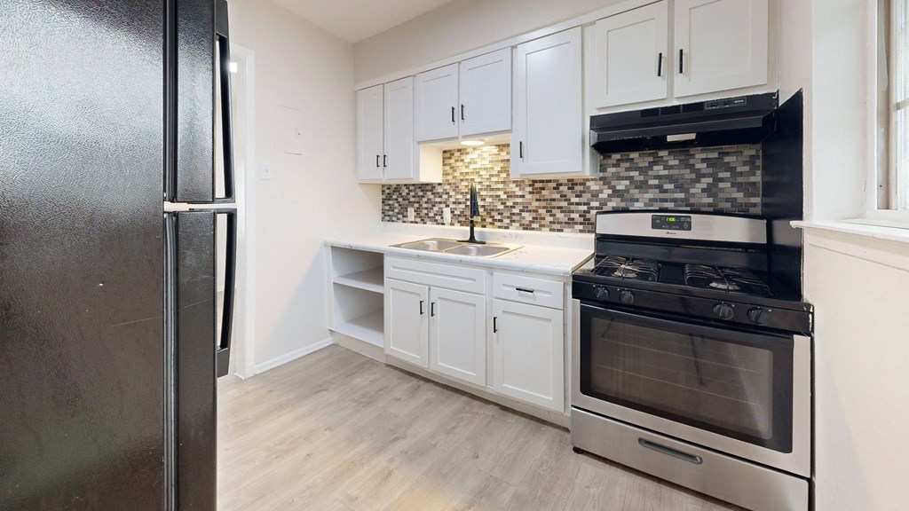 a kitchen with stainless steel appliances and white cabinets