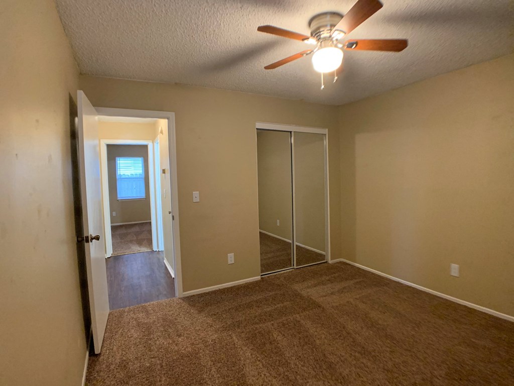 bedroom with ceiling fan and closets