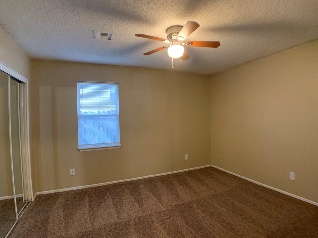bedroom with ceiling fan and closets