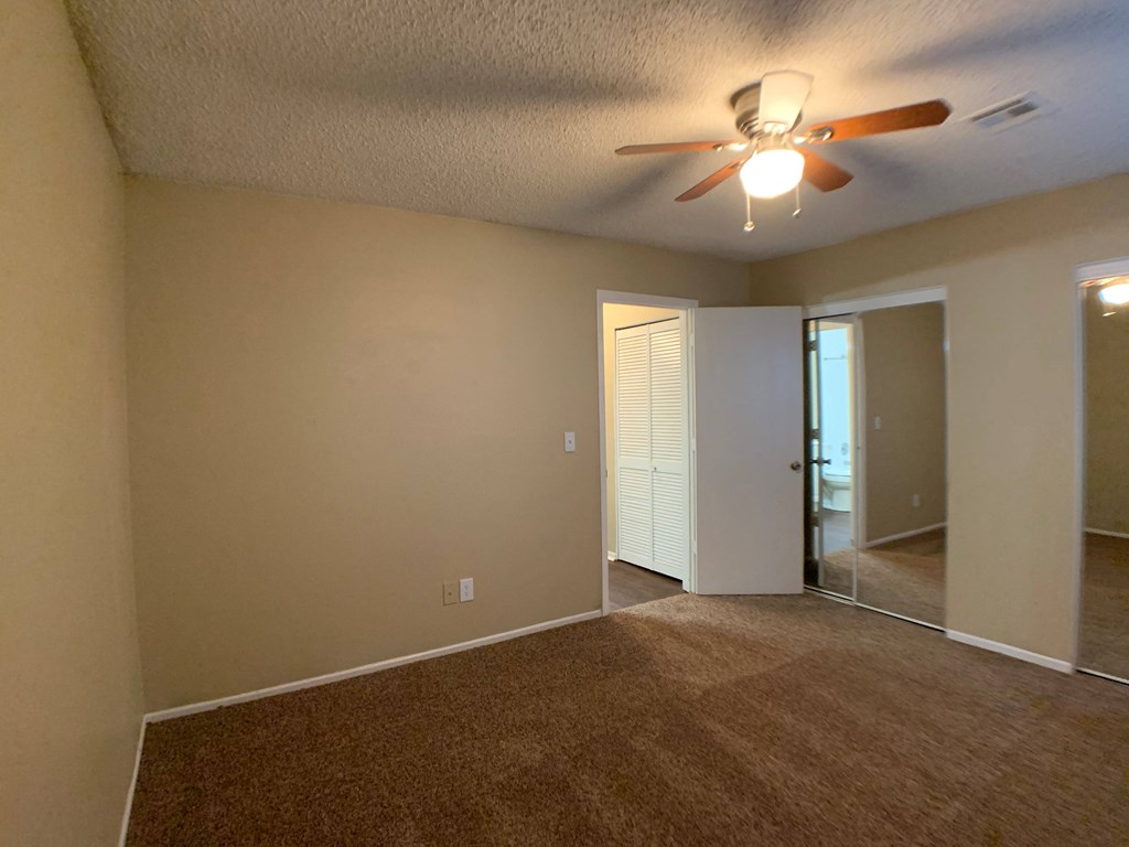bedroom with ceiling fan and closets