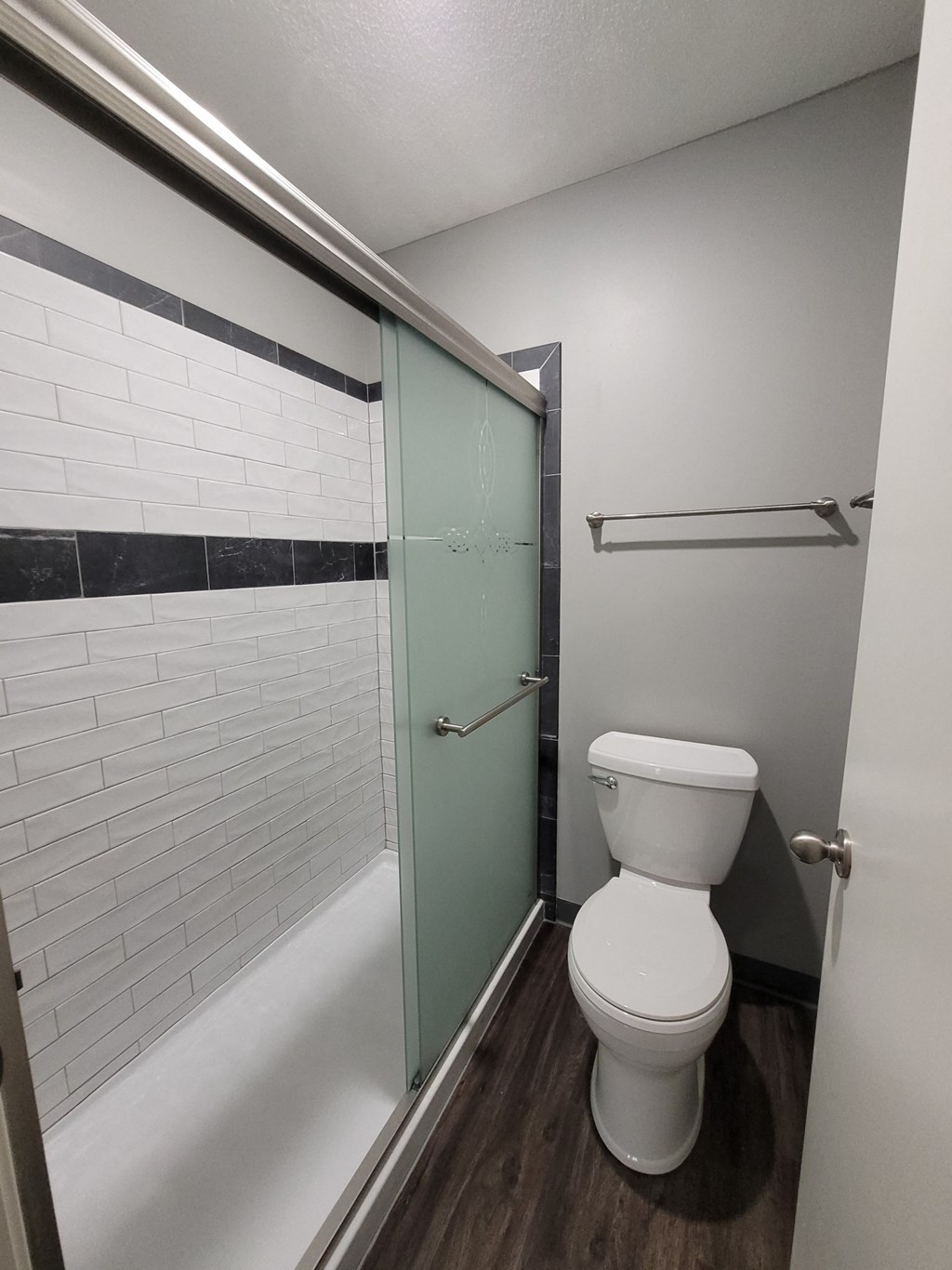 Photo of bathroom with toilet and shower with sliding door in Fairway, Kansas.