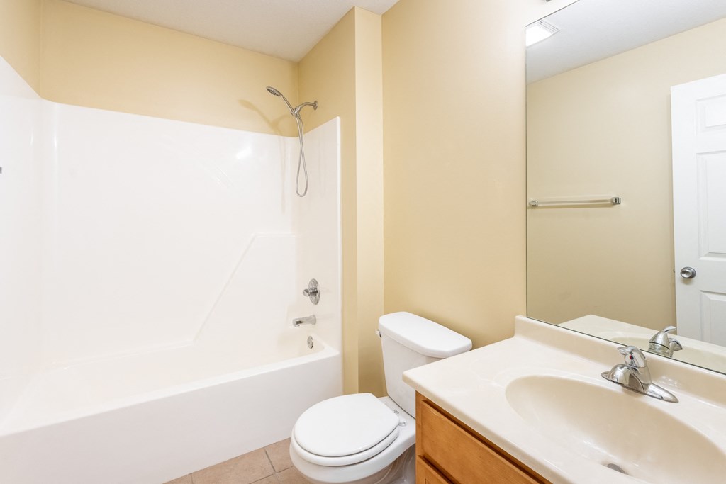 Photo of bathroom with wooden cabinetry and combination bathtub and shower in Peoria.