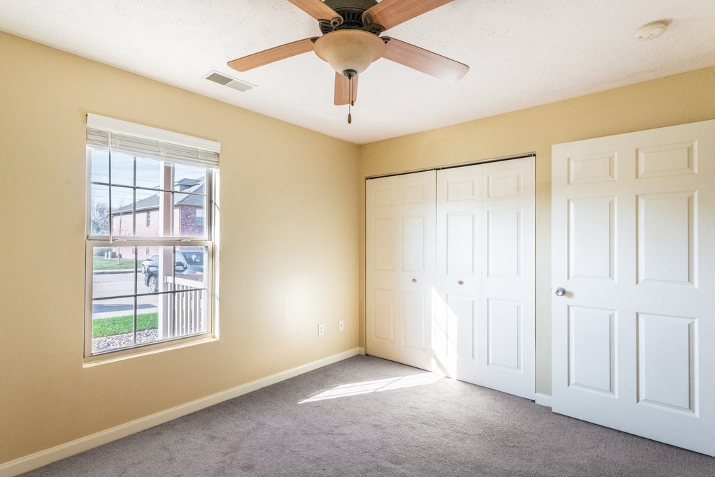 Photo of carpeted bedroom with view of closet and window facing the sun in Peoria.